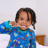 Image of a boy brushing his teeth wearing Ducky Zebra sustainable pyjamas, with a fun space print.