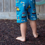girl and boy unisex shorts with a teal background and fun campervan and paddleboard print