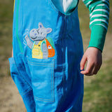 A hippo appliqué peaking out of a pocket on a pair of organic cotton unisex dungarees by Ducky Zebra