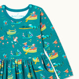 Close up of teal Skater Dress with repeat print pattern of a highland cow, otter and king fisher rowing, wild swimming and exploring together. The dress has buttons on the neck for easy dressing