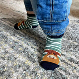 Close up of green sock with an image of a highland cow