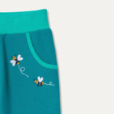 Close up of two embroidered bees by pocket of teal joggers
