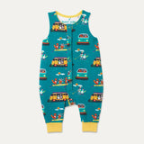 Ducky Zebra teal sleeveless romper with a campervan and paddleboard repeat print. The romper has contrasting yellow cuffs, which have been folded up. It has orange poppers down the front.