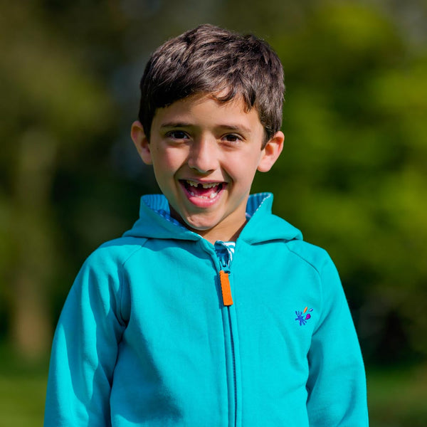 Image of smiling boy wearing a Ducky Zebra turquoise hoodie