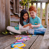 Image of two children sitting in a tree house, wearing Ducky Zebra clothes, playing with the Conversation Cards
