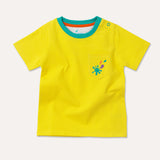 Image of a yellow baby and kids t-shirt with a turquoise neck ribbing, two turquoise poppers on the shoulder and a yellow pocket with a turquoise, purple and orange splash print