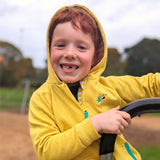 A smiling boy with a big gap in his teeth. He is wearing a yellow Ducky Zebra hoody with a zip.