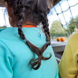 Image of the back of a girl, wearing a light green Ducky Zebra t-shirt with an embroidered splash power button below the neck line. 