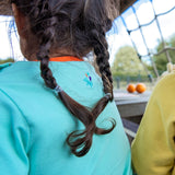 Image of the back of a girl, wearing a light green Ducky Zebra t-shirt with an embroidered splash power button below the neck line.