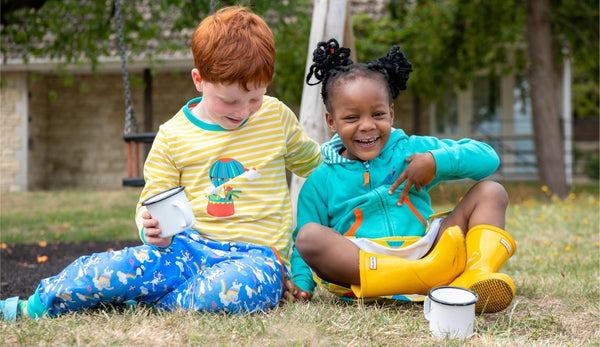 Girl and boy drinking hot chocolate outside wearing fun, sustainable kids clothes by Ducky Zebra