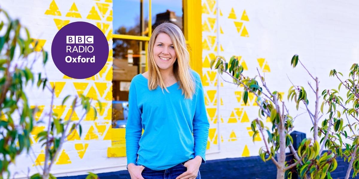Image of Sally Dear, founder of Ducky Zebra, smiling at the camera with the BBC Radio Oxford logo to her side