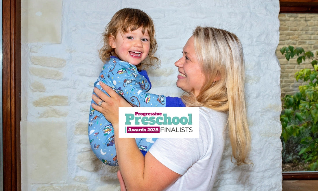 Smiling mum holding up a smiling toddler, who's wearing A Ducky Zebra x Roald Dahl Sleepsuit. The photo has the logo 'Progressive Preschool Awards 2025 Finalists'