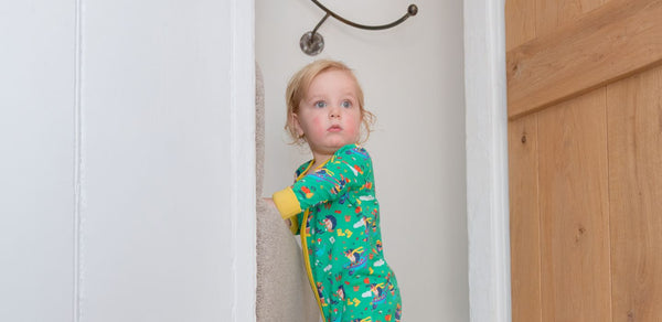 Image of toddler standing on the stairs wearing Ducky Zebra clothes looking confused