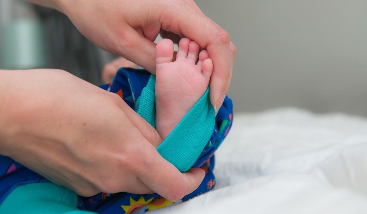 newborn baby's foot - showing a unisex baby romper