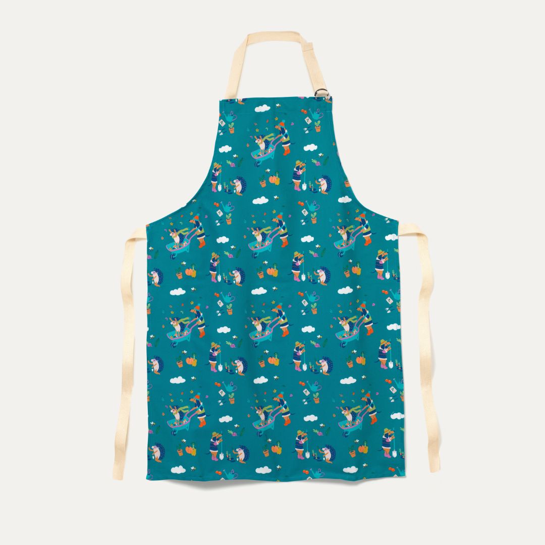Ducky Zebra Teal Adult Apron, with Adjustable buckle strap. The apron has a repeat print pattern of a dog and hedgehog gardening and playing in a wheelbarrow