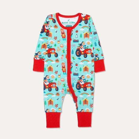 Sustainable baby zip-up sleepsuit with a pale blue background and a fun repeat print of a sheep and pig driving their red tractor and looking after their bees. The sustainable romper has red contrasting cuffs, a two-way zip and chin guard. The cuffs are rolled-down in the picture.