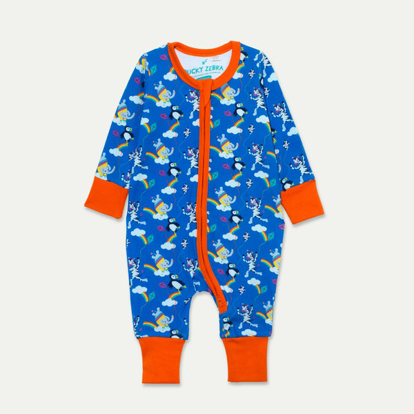 Zip-up unisex baby sleepsuit with a bright blue background and colourful print of an elephant, zebra and puffin flying a kite. The baby romper has flame orange arm cuffs, trim and two way zip.