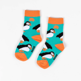 Pair of children's socks with turquoise background, orange trim and repeat puffin print