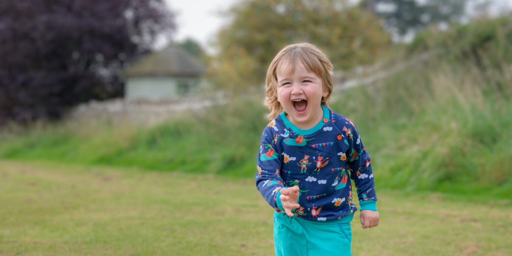 Boy wearing colourful organic cotton Ducky Zebra sweatshirt. 