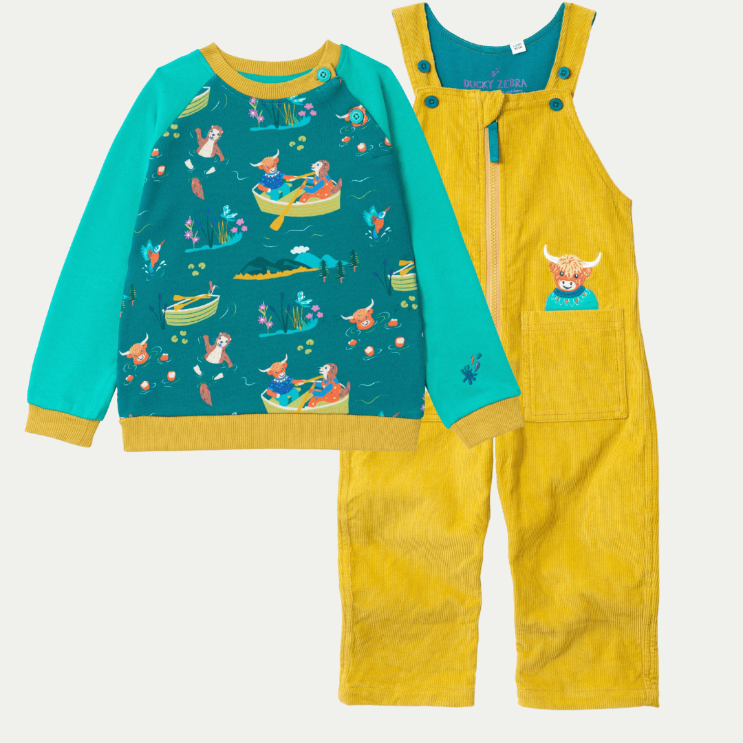 Children's outfit with teal shirt and yellow overalls on a white background