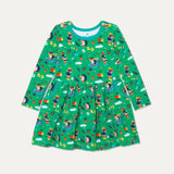 Green long sleeve kids' skater dress with fun repeat print of a dog and hedgehog playing in a wheelbarrow and gardening. The print includes bees, pumpkins, carrots and wellies. The dress has two deep pockets with a turquoise trim and contrasting yellow buttons on the shoulders. 