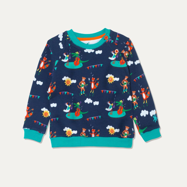 Image of blue jumper with a fun print of a cheetah, fox, duck and crocodile playing music together. The jumper has a festival vibe. It has two orange buttons on the shoulder for easy dressing and contrasting turquoise cuffs. 