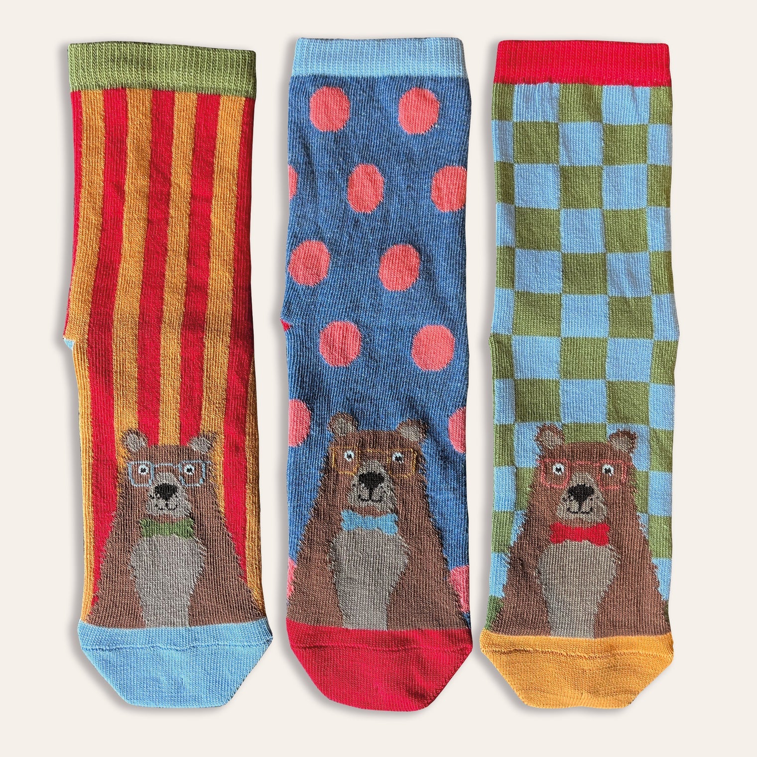 Pack of three children's socks with bears on each. The socks are brightly coloured with stripes, cheques and spots.