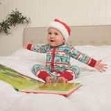 Baby wearing festive sleepsuit, featuring Roald Dahl mice. They're wearing a Christmas hat and reading a book