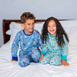 Smiling girl and boy wearing Ducky Zebra x Roald Dahl unisex kids' PJs