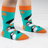Child wearing fun puffin socks with turquoise background and orange trim