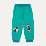 Turquoise cord kid trousers with teal waistband and cuff. The colourful Ducky Zebra trousers have a fun appliqué of a dog and hedgehog throwing leaves at one another