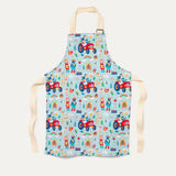 Children's apron with light turquoise background and fun farmyard print with tractors, pigs and sheep