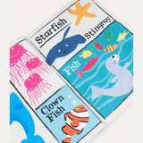 Close up of a Crinkly Cloth newspaper with images of a seal, clown fish, octopus and star fish