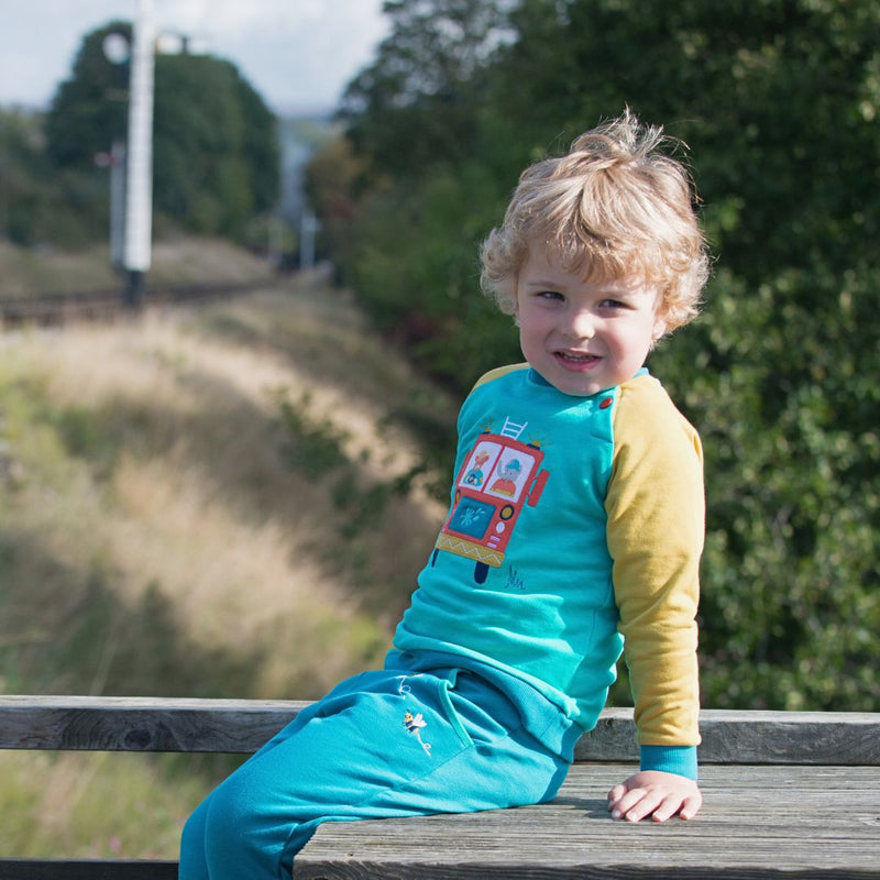 Child wearing Ducky Zebra Fire Engine Sweatshirt and Teal Joggers with bee embroidery. 
