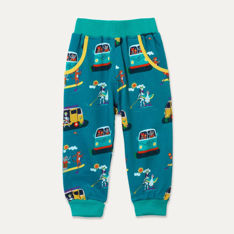 Ducky Zebra teal joggers with a turquoise waistband and cuff. The trousers have two deep pockets and a repeat print pattern of animals playing with campervans and paddleboards. 