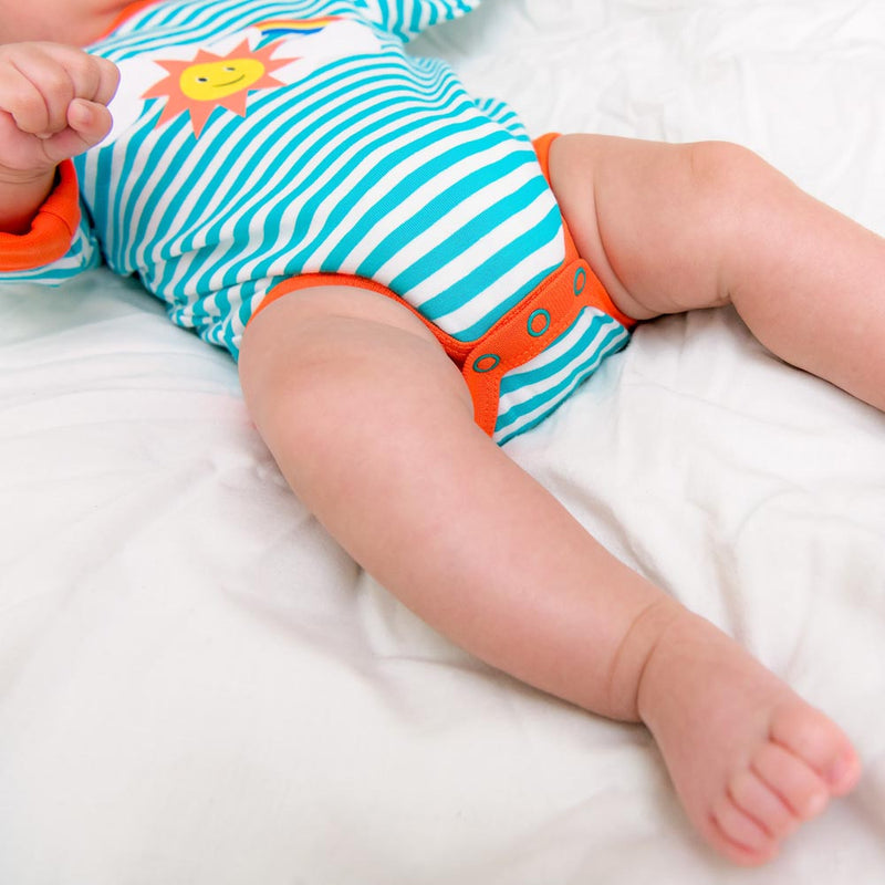 Image of a baby wearing long sleeve turquoise stripe bodysuit with flame orange trim and roll-up arm cuffs. The image shows the bottom half of the bodysuit, including three turquoise poppers on the crotch