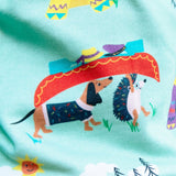 Close up image of a dog and hedgehog carrying a boat together on their heads. The print is on a pair of unisex Ducky Zebra trousers