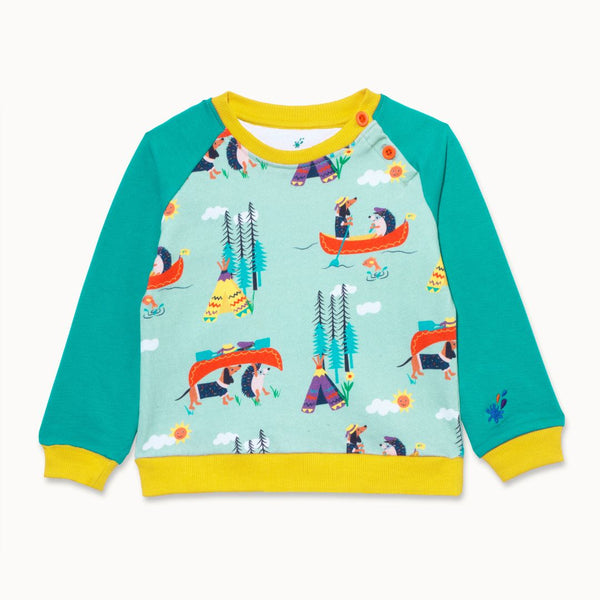 Image of a Ducky Zebra unisex sweatshirt with a repeat print of a dog and hedgehog canoeing and camping together. The sweatshirt has a pale green background, turquoise sleeves and a yellow trim.