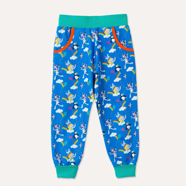 Bright blue joggers, with two deep pockets with an orange trim. Elasticated turquoise waistband and roll-up cuffs. Repeat print patter with a colourful elephant, zebra and puffin flying kites together. 