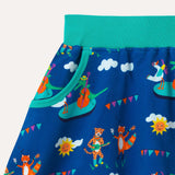 Image of a Ducky Zebra kids skirt with a festival repeat print pattern, including a double base playing crocodile, saxophone playing duck, maraca shaking fox and ukulele playing cheetah. Image focuses on one of the two pockets with a turquoise trim and the turquoise elasticated waistband. 
