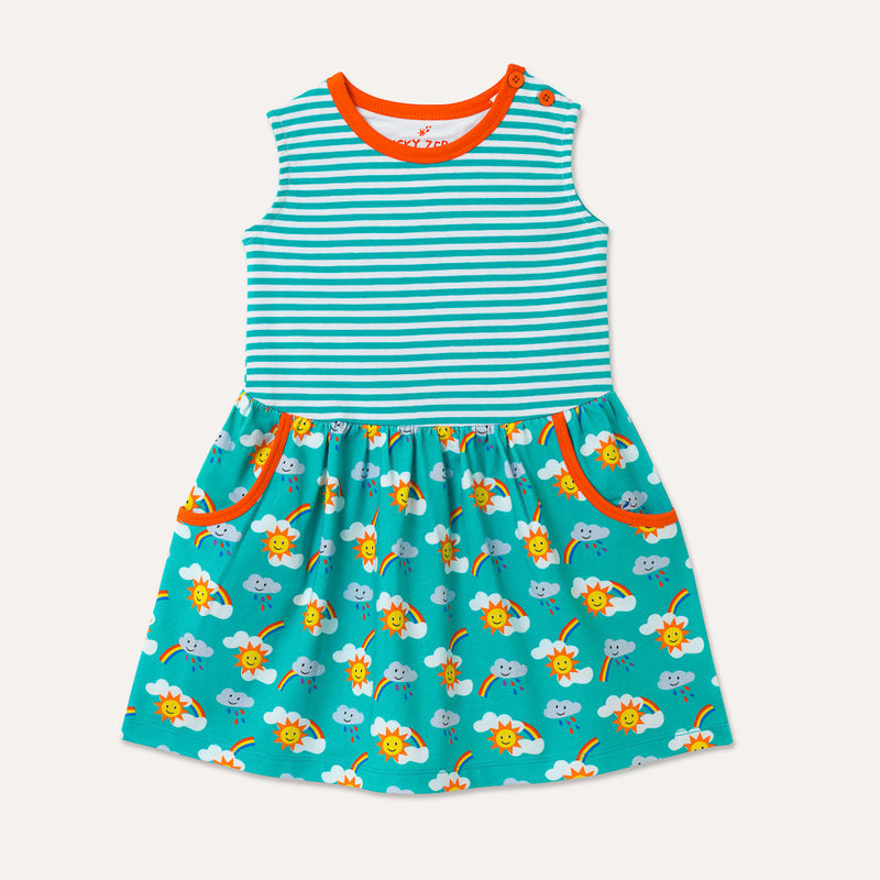 Image of sleeveless kids dress with turquoise stripe top half and rainbow print bottom half, displaying two large pockets with orange trim