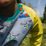 Close up image of a child wearing a Ducky Zebra jumper, with a focus on the neckline and orange buttons