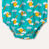 Image of a unisex sleeveless baby bodysuit with a turquoise background and repeat print pattern of rainbows, sun and clouds. The image shows the bottom half of the bodysuit with elasticated leg opening and three turquoise poppers at the crotch