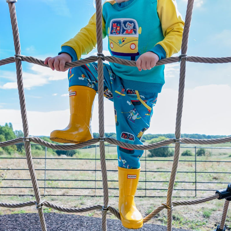 Child on a climbing frame wearing Ducky Zebra joggers and sweatshirt with bright yellow wellies