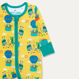 Close up image of a Ducky Zebra baby sleepsuit. The sleepsuit has a yellow background with a repeat print pattern of a crocodile and elephant enjoying a hot air balloon ride and playing in the leaves. The sleepsuit has a contrasting turquoise two-way zip and roll-down cuffs.