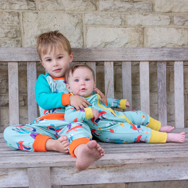 Image of a toddler cuddling his sister on a bench. The children are wearing twinning Ducky Zebra outfits. 
