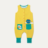 Yellow baby dungarees with turquoise pockets and turquoise roll-up cuffs.. One pocket has an applique of a sun and cloud. The other has an applique of a hot air balloon poking out of it. The dungarees have orange poppers down the front for easy dressing. 